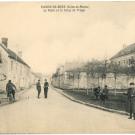 Carte postale, vue d'une rue de Fleury-en-Brie, des hommes en uniformes et armés sont postés dans la rue.