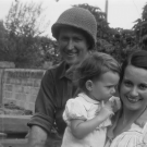 Photographie d'un soldat et devant lui une femme portant un enfant