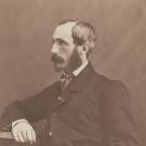 Potrait assis de Foucher de Careil, il porte une veste de costume sombre et sa main droite est posée sur une table