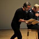 Vue de Marc Roger lisant en compagnie de l'accordéoniste Laurent Derache
