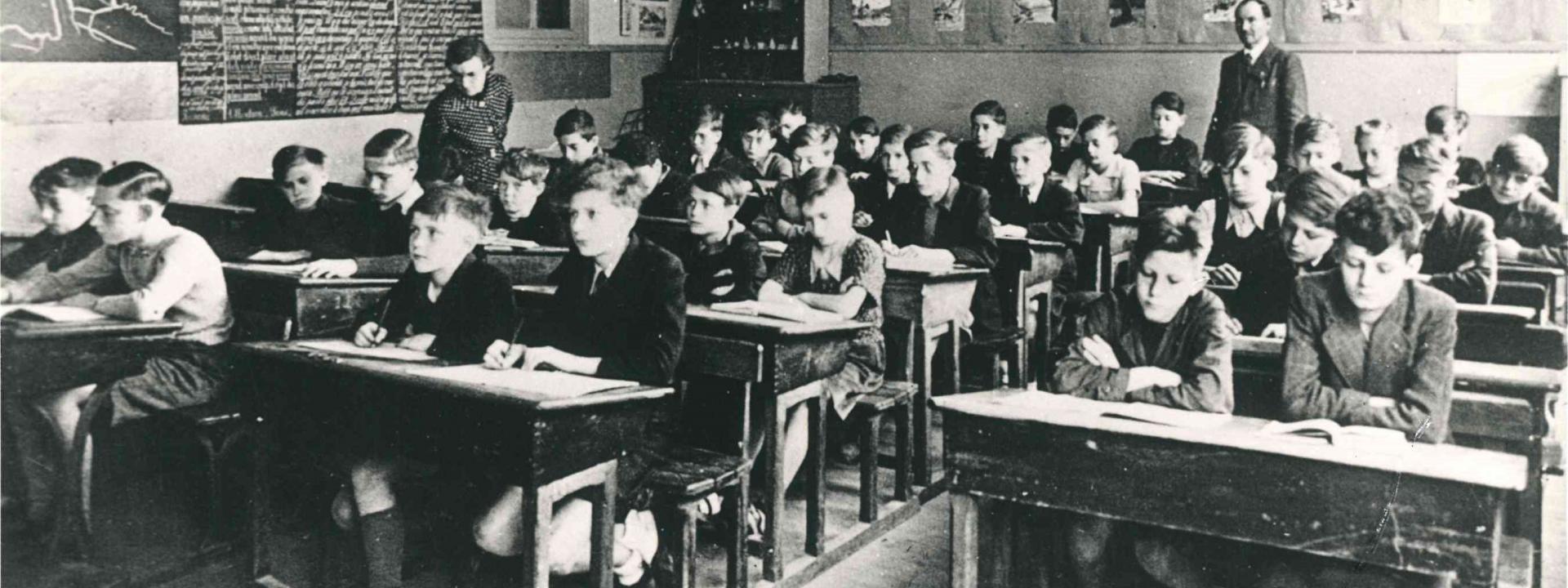 Vue d'une salle de classe de l'école de garçons de l'école Pasteur de Melun en 1943 ou 1944. Un portrait du Maréchal Pétain est accroché au fond de la salle.