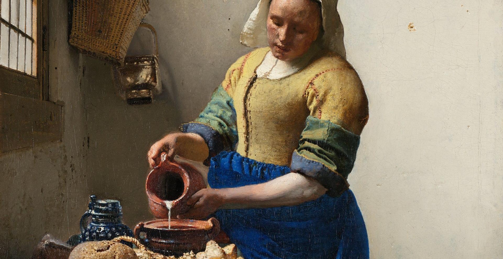 Femme vêtue portant un bonnet blanc et versant du lait dans un récipient.