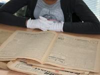 Élève cherchant des informations dans un journal