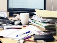 Pils de dossiers sur un bureau.