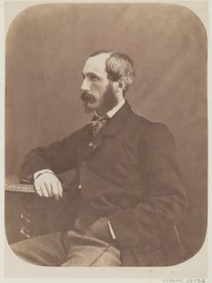 Portrait assis de Foucher de Careil, il porte une veste de costume sombre, est tourné de trois quart et sa main est posée sur une table