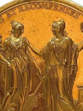 Médaille dorée, sur laquelle sont représentées deux figures féminines et surmontéer de l'inscription "Encouragements et récompenses à l'industrie