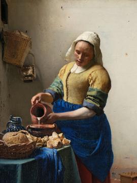 Femme vêtue portant un bonnet blanc et versant du lait dans un récipient.