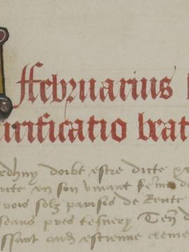 texte de manuscrits avec une lettrine, une première ligne écrite en couleur rouge et la suite de couleur marron