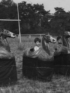 Enfants jouant aux chevaux de bois