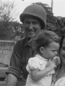 Photographie d'un soldat et devant lui une femme portant un enfant