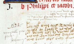 Vue d'un détail d'une page d'un manuscrit avec une lettrine et des écritures gothiques, cursifs