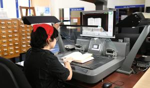 Numérisation sur le scanner en salle de lecture par une utilisatrice.