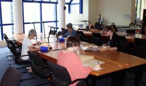 Lecteurs consultant des documents en salle de lecture des Archives
