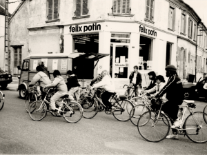 Groupe de cycliste passant devant une devanture "félix potin"
