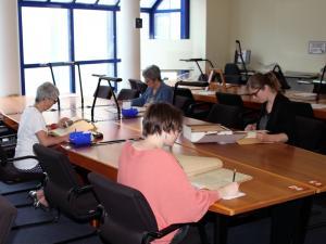 Lecteurs consultant des documents en salle de lecture des Archives