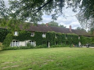 Bâtiment en longueur à la surface couverte de lière, grande pelouse devant