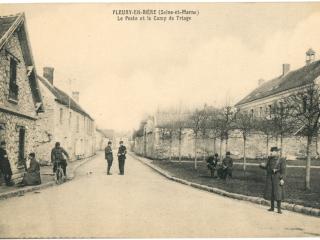 Carte postale, vue d'une rue de Fleury-en-Brie, des hommes en uniformes et armés sont postés dans la rue.