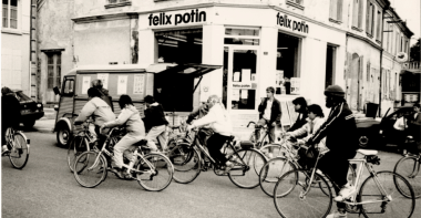 Groupe de cycliste passant devant une devanture "félix potin"