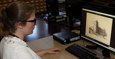 Consultation d'archives sur ordinateur en salle de lecture