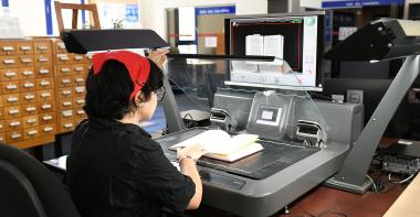 Numérisation sur le scanner en salle de lecture par une utilisatrice.