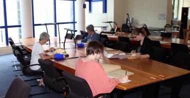 Lecteurs consultant des documents en salle de lecture des Archives