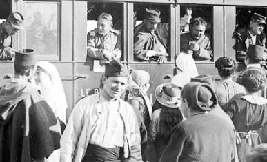 Photographie montrant des soldats métropolitains et coloniaux dans un train et sur le quai d'une gare en présence d'infirmières et de civils (dont des enfants)