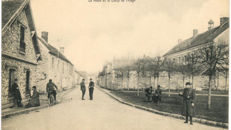 Carte postale, vue d'une rue de Fleury-en-Brie, des hommes en uniformes et armés sont postés dans la rue.