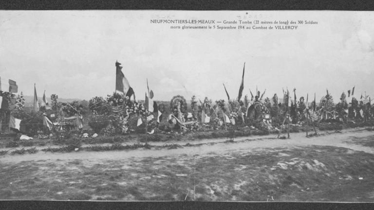 photographie en noir et blanc de nombreuses tombes fleuries et ornées de drapeaux