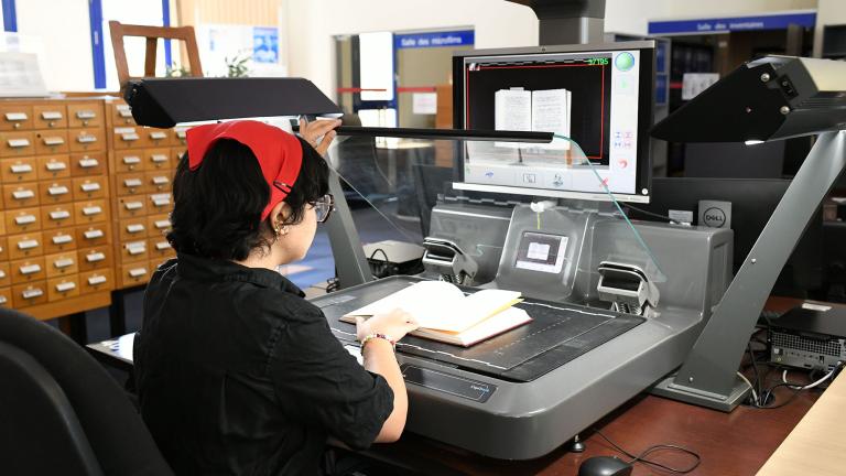 Numérisation sur le scanner en salle de lecture par une utilisatrice.